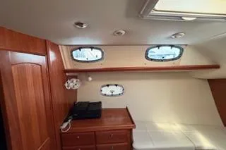 Slide: The Image of 2009 Hunter 50 Center Cockpit interior with wood cabinetry and porthole windows. - 26