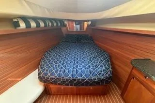 Slide: The Image of 2009 Hunter 50 Center Cockpit interior with cozy bed and wooden paneling. - 29