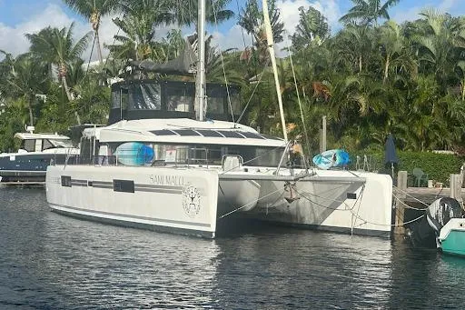 The Image of 2017 Lagoon 52 F catamaran docked by tropical palm trees. - 0