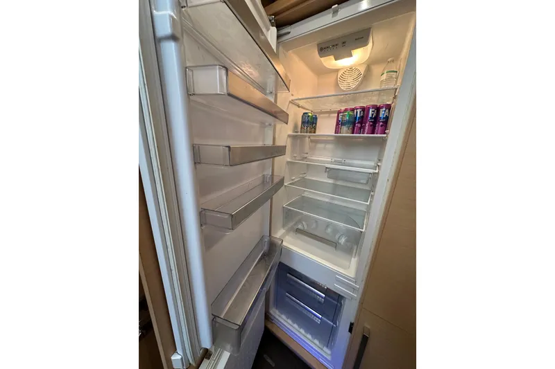 Slide: The Image of Open refrigerator inside 2017 Lagoon 52 F yacht, stocked with drinks and water bottles. - 27