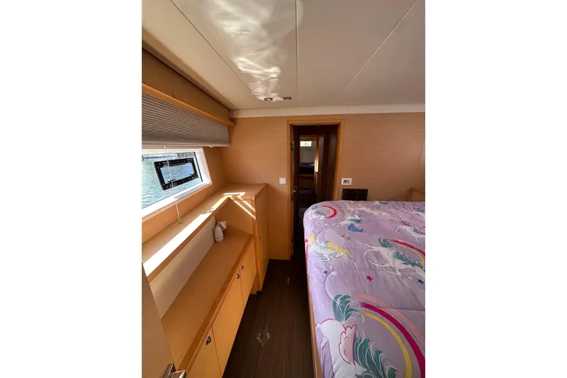 Slide: The Image of Interior of 2017 Lagoon 52 F yacht cabin with colorful bedding and wooden furnishings. - 42
