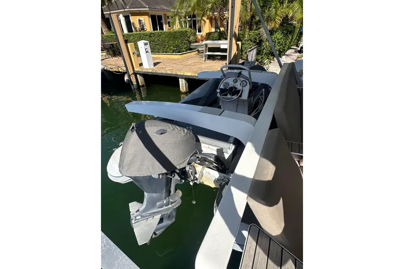 Slide: The Image of 2017 Lagoon 52 F boat docked, featuring an outboard motor and steering console. - 54
