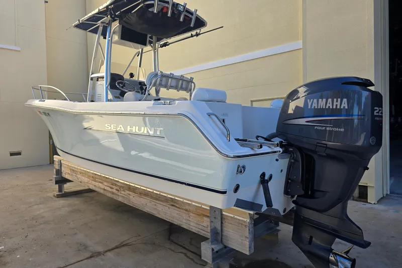 The Image of 2008 Sea Hunt Triton 220 boat with Yamaha 225 four-stroke engine on a stand. - 1