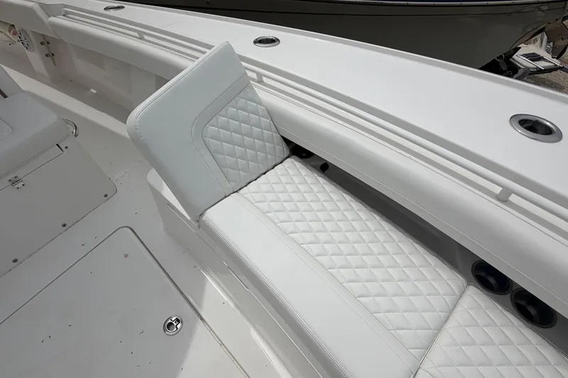 Slide: The Image of 2026 Regulator 28 boat interior with white quilted seating and cup holders. - 11