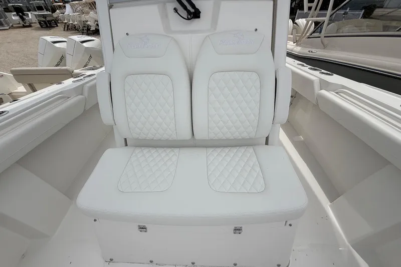 Slide: The Image of 2026 Regulator 28 boat with white cushioned seating and diamond stitching design. - 12