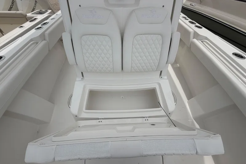 Slide: The Image of 2026 Regulator 28 boat interior with white cushioned seating and storage compartment. - 13