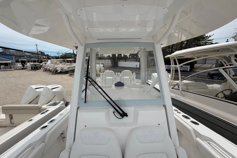 Slide: The Image of 2026 Regulator 28 boat interior with seating and Mercury engines in a marina setting. - 14