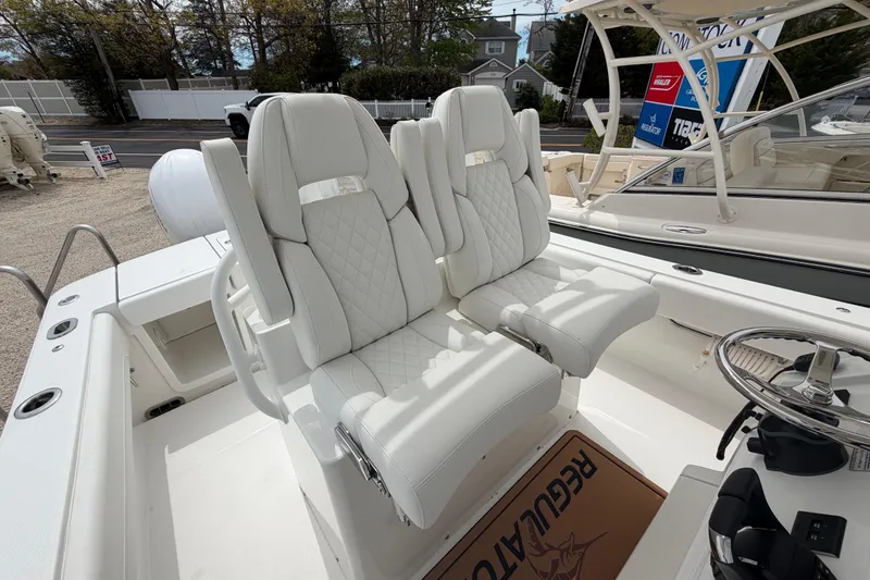 Slide: The Image of Luxury seating on 2026 Regulator 28 boat, featuring white quilted upholstery and modern helm design. - 22