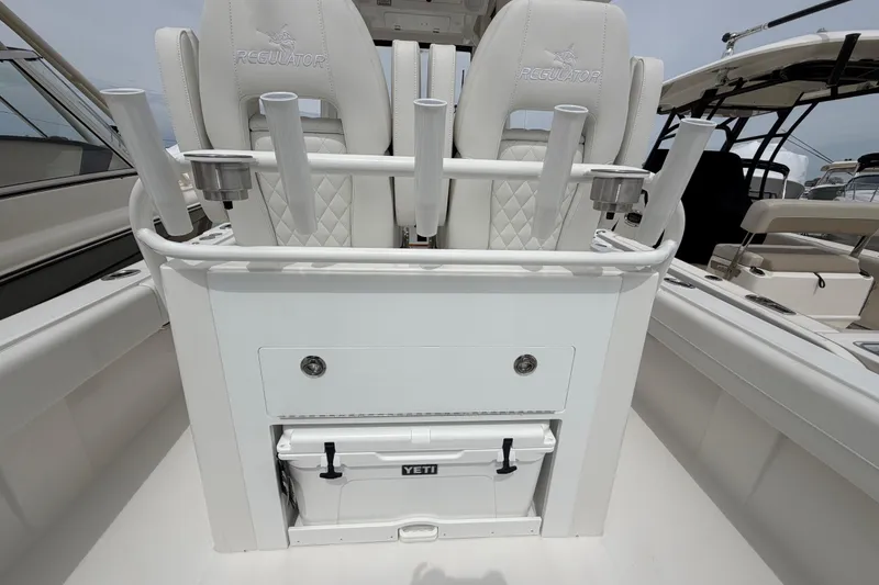 Slide: The Image of 2026 Regulator 28 boat interior with rod holders and Yeti cooler. - 24