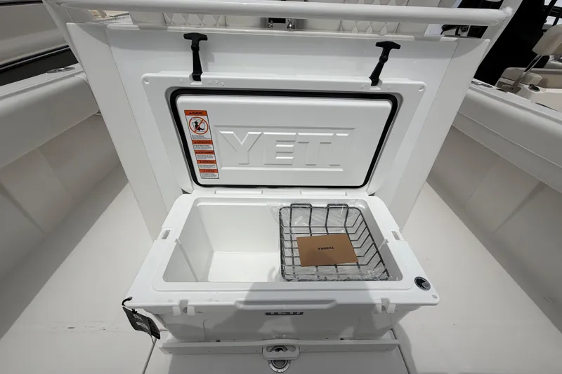 Slide: The Image of Open YETI cooler on 2026 Regulator 28 boat, showcasing interior storage space. - 25