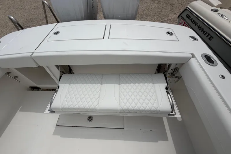 Slide: The Image of 2026 Regulator 28 boat with fold-out white cushioned seat and storage compartments. - 27