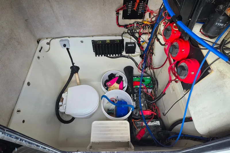 Slide: The Image of 1999 Hydra-Sports 3000 CC boat interior with wiring, battery, and equipment storage. - 18