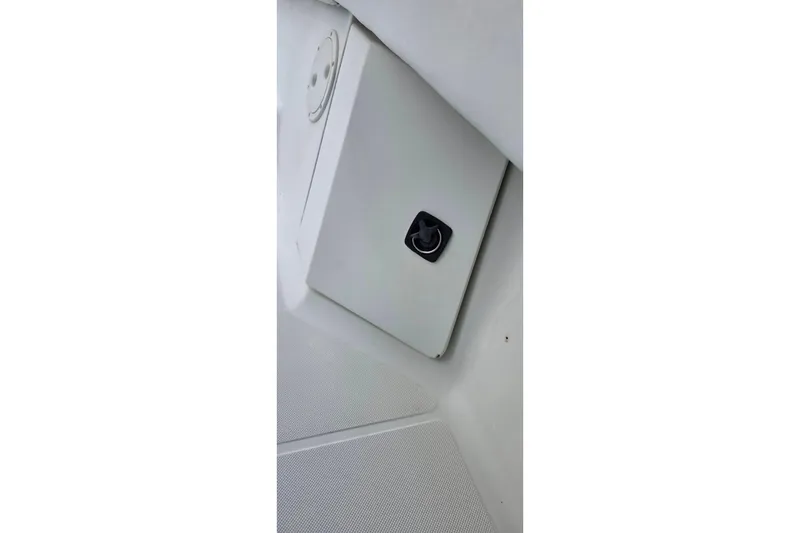 Slide: The Image of 1999 Hydra-Sports 3000 CC boat compartment with latch, white interior. - 25