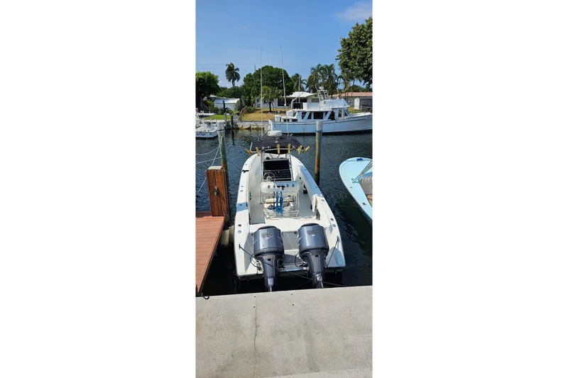Slide: The Image of 1999 Hydra-Sports 3000 CC boat docked at marina with twin outboard motors. - 3