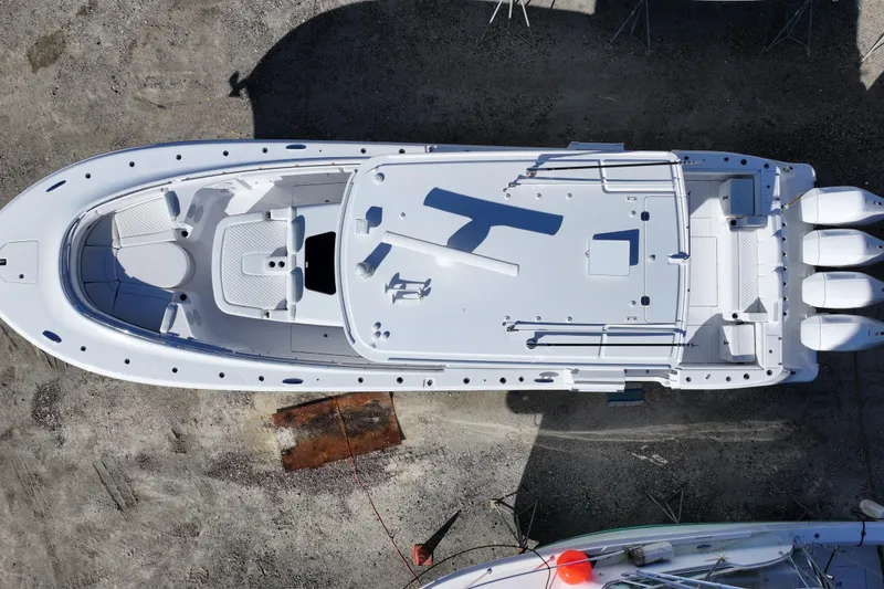 Slide: The Image of Aerial view of 2026 HCB 48 Campeon boat with triple engines, docked on land. - 10