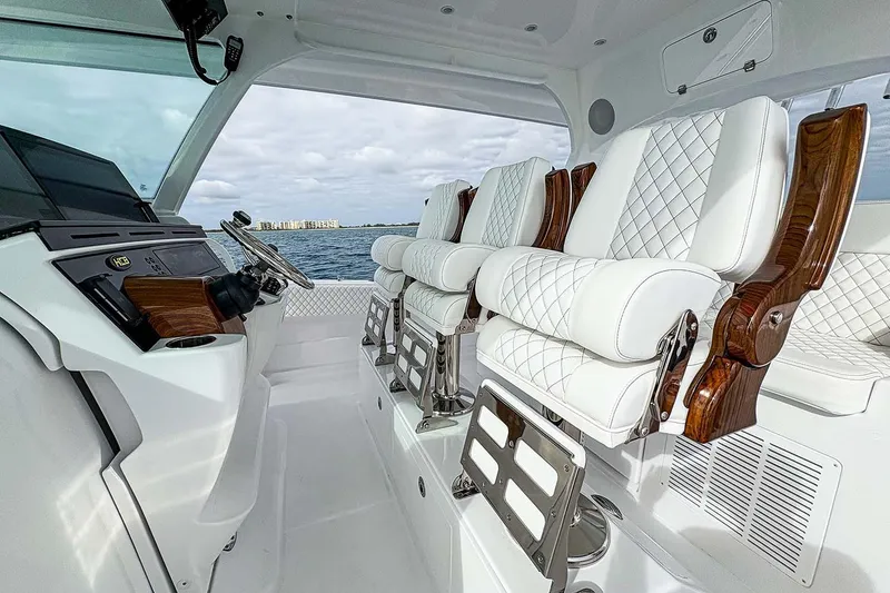Slide: The Image of Manufacturer Provided Image: Luxurious interior of 2026 HCB 48 Campeon boat with plush white seating and modern controls. - 23