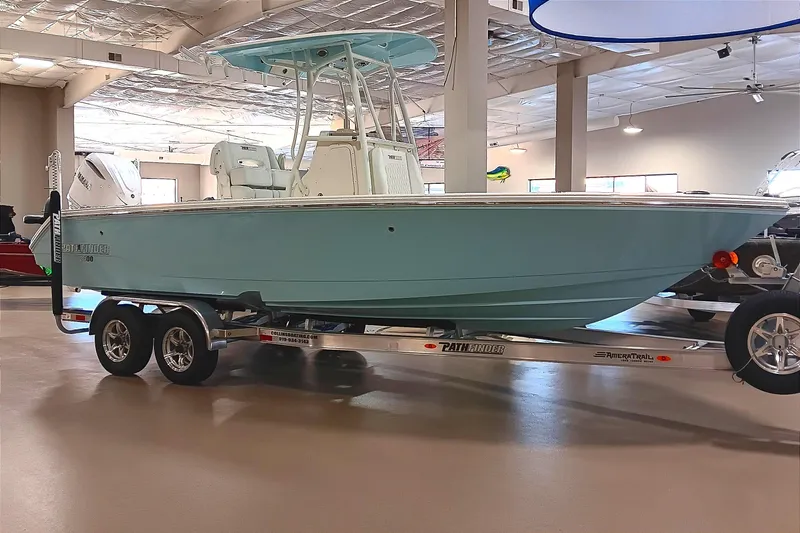The Image of 2026 Pathfinder 2400 TRS boat on trailer in showroom, light blue hull. - 0
