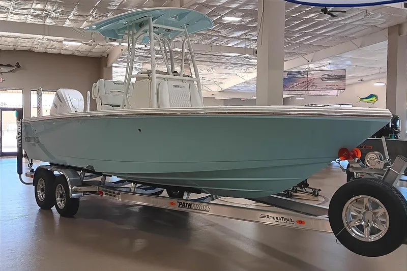 Slide: The Image of 2026 Pathfinder 2400 TRS boat on trailer in showroom, light blue hull, modern design. - 1