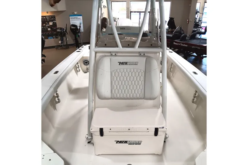Slide: The Image of 2026 Pathfinder 2400 TRS boat interior with seating and storage, displayed in showroom. - 14