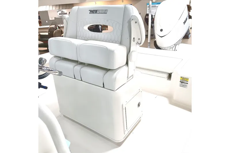 Slide: The Image of 2026 Pathfinder 2400 TRS boat interior with white cushioned seating and steering console. - 17