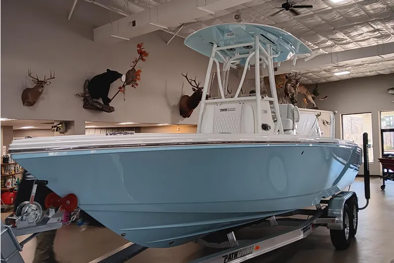 Slide: The Image of 2026 Pathfinder 2400 TRS boat displayed indoors with mounted wildlife decor. - 2