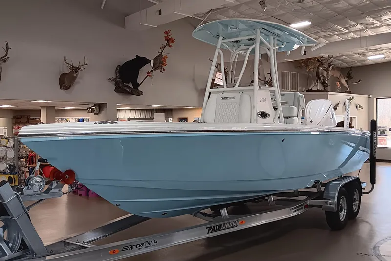 Slide: The Image of 2026 Pathfinder 2400 TRS boat in showroom, light blue hull, on trailer. - 3