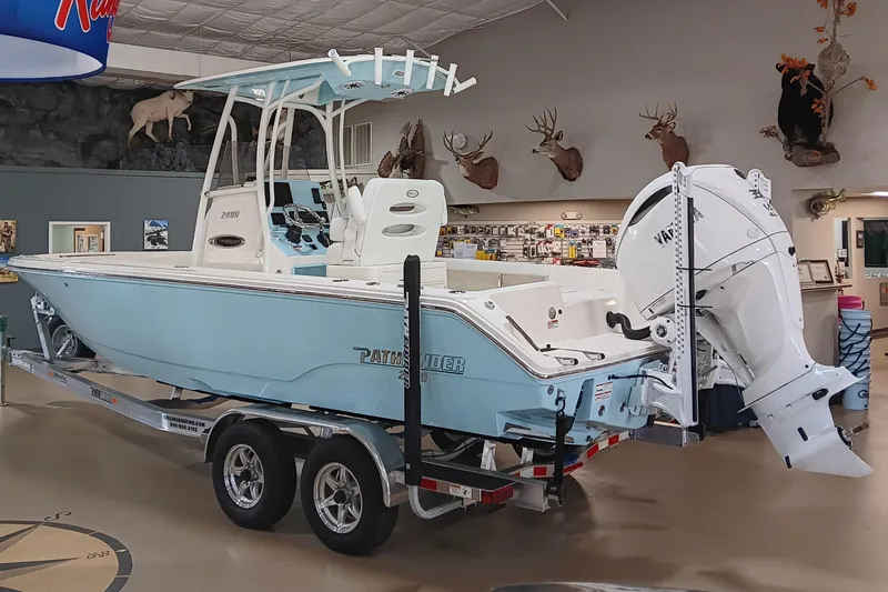 Slide: The Image of 2026 Pathfinder 2400 TRS boat displayed indoors with mounted engine and trailer. - 4