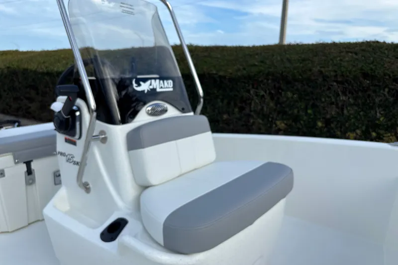 Slide: The Image of 2026 Mako Pro Skiff 15 CC boat console with seating and steering wheel. - 12