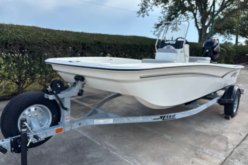 Slide: The Image of 2026 Mako Pro Skiff 15 CC boat on trailer, parked outdoors. - 1