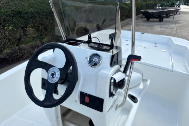 Slide: The Image of 2026 Mako Pro Skiff 15 CC boat console with steering wheel and controls. - 10