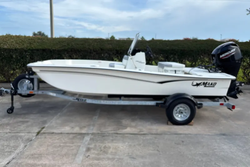 The Image of 2026 Mako Pro Skiff 15 CC boat on trailer, side view, outdoors. - 0
