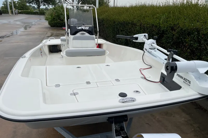 Slide: The Image of 2026 Mako Pro Skiff 15 CC boat with Minn Kota trolling motor on a trailer. - 10