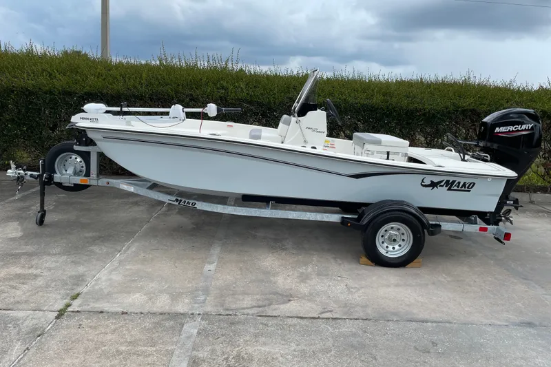 The Image of 2026 Mako Pro Skiff 15 CC boat on trailer, featuring Mercury outboard motor. - 0