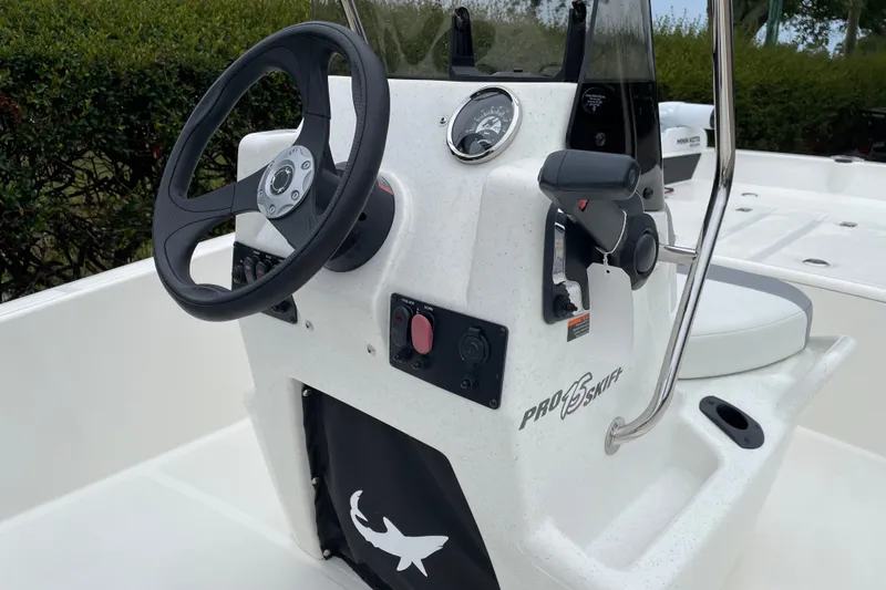 Slide: The Image of 2026 Mako Pro Skiff 15 CC boat console with steering wheel and controls. - 12