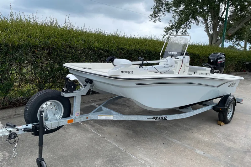 Slide: The Image of 2026 Mako Pro Skiff 15 CC boat on trailer, parked outdoors. - 1