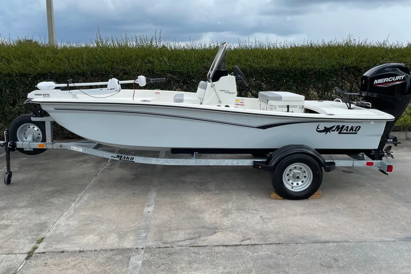 The Image of 2026 Mako Pro Skiff 15 CC boat on trailer, featuring Mercury outboard motor. - 0