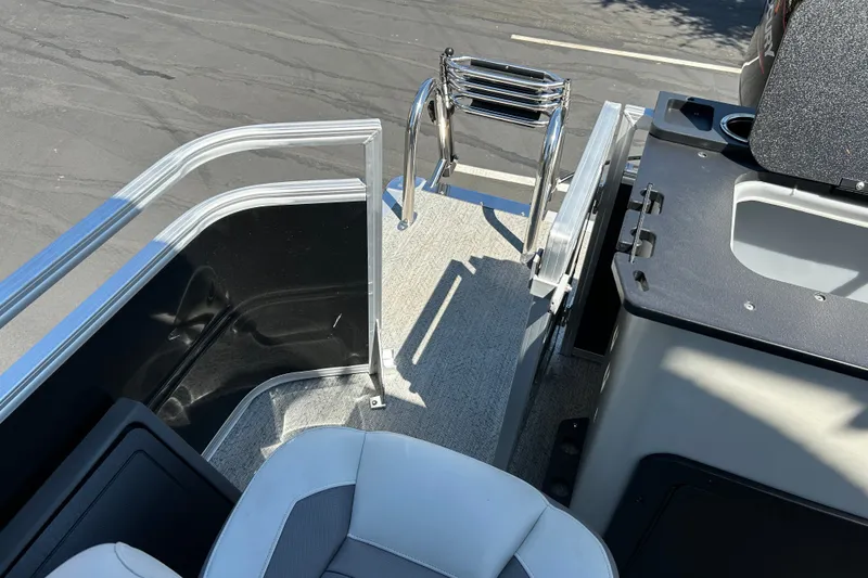 Slide: The Image of 2026 Sun Tracker Fishin' Barge 22 DLX interior with seating and ladder detail. - 26