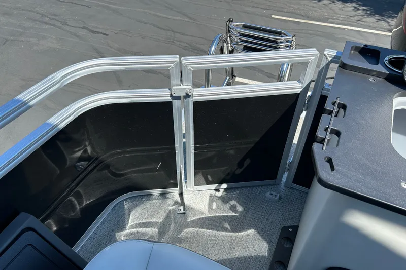 Slide: The Image of 2026 Sun Tracker Fishin' Barge 22 DLX interior with railing and seating area. - 24