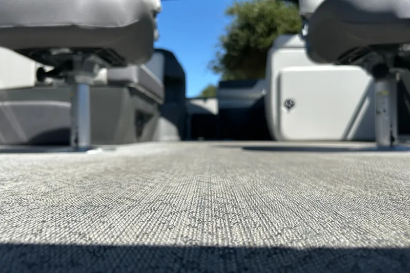 Slide: The Image of 2026 Sun Tracker Fishin' Barge 22 DLX interior with seating and textured flooring. - 32