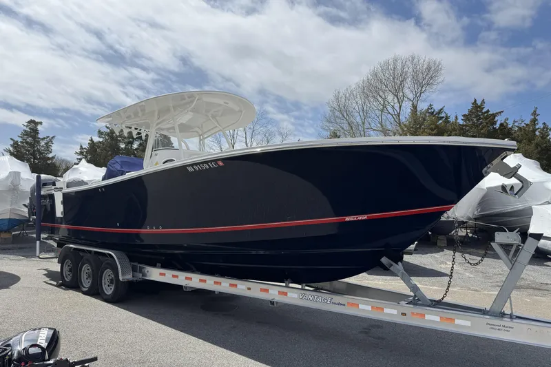 Slide: The Image of 2018 Regulator 34SS boat on trailer, parked outdoors under cloudy sky. - 100