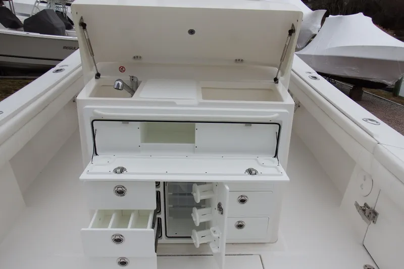 Slide: The Image of 2018 Regulator 34SS boat with open storage compartments and sink. - 12