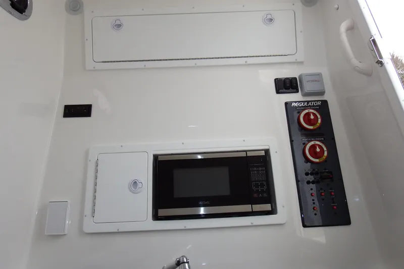 Slide: The Image of 2018 Regulator 34SS interior with microwave, control panel, and storage compartments. - 21