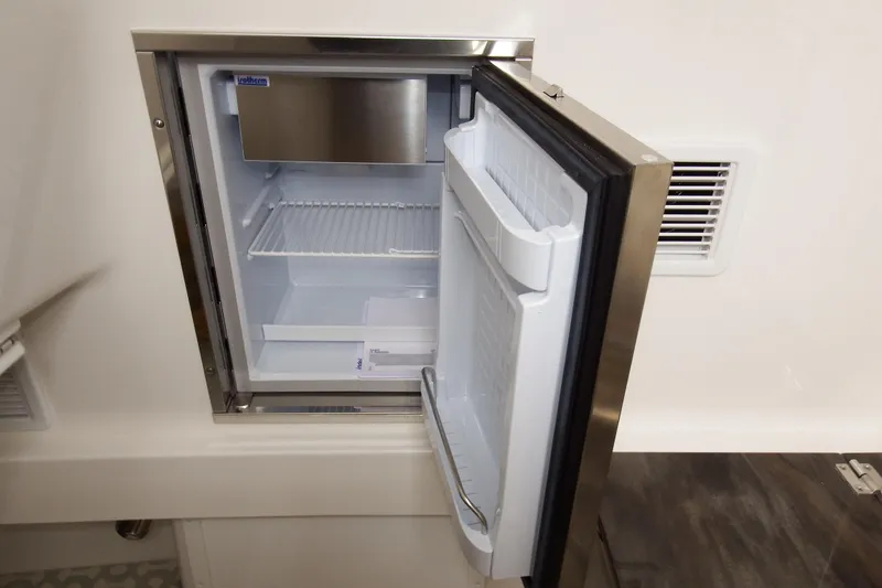 Slide: The Image of Open refrigerator on 2018 Regulator 34SS boat, showcasing interior storage space. - 23