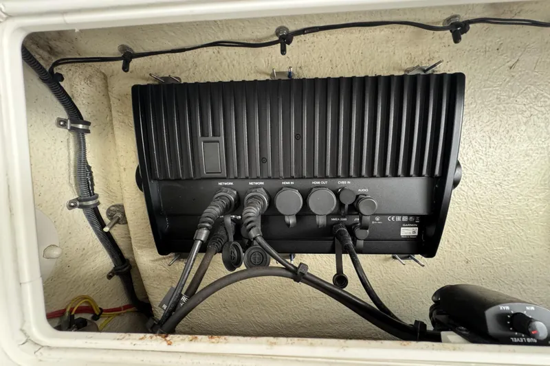 Slide: The Image of 2018 Regulator 34SS boat electronics panel with various cable connections. - 49