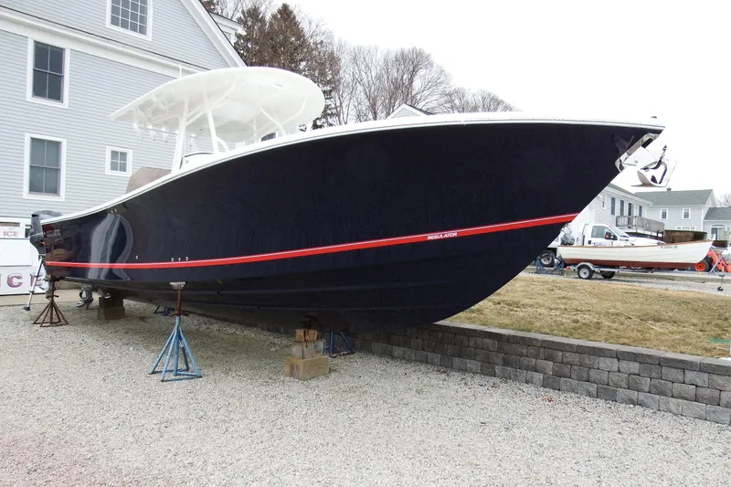 Slide: The Image of 2018 Regulator 34SS boat on stands, displayed outdoors near buildings. - 5