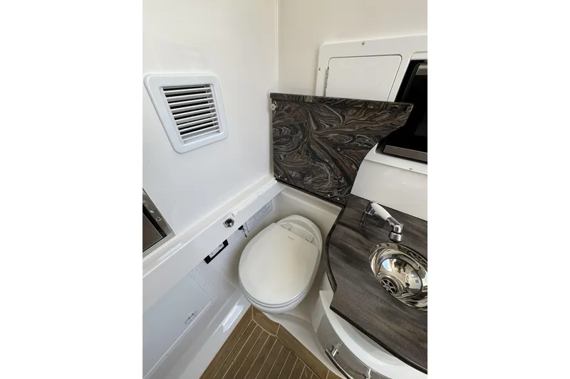 Slide: The Image of 2018 Regulator 34SS boat bathroom with modern sink and toilet design. - 54