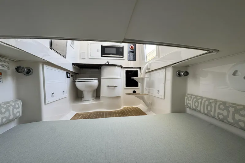 Slide: The Image of 2018 Regulator 34SS cabin interior with toilet, microwave, and seating area. - 59