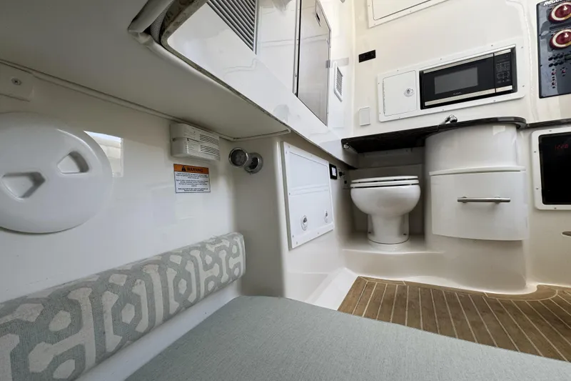 Slide: The Image of Interior of 2018 Regulator 34SS boat featuring a compact bathroom and kitchenette area. - 61