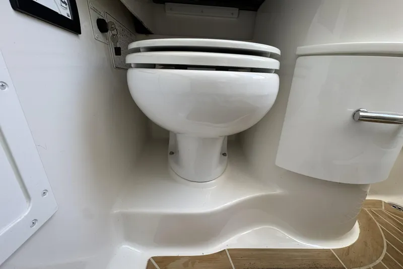 Slide: The Image of 2018 Regulator 34SS boat interior with a white marine toilet. - 62