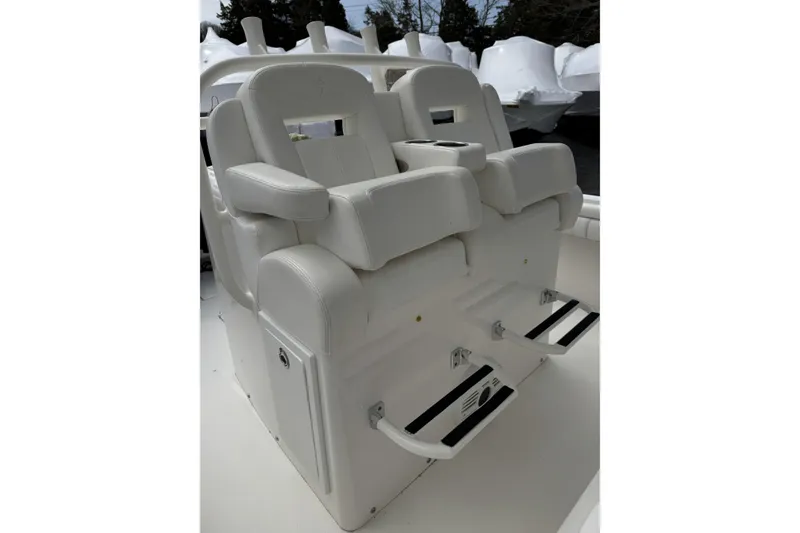 Slide: The Image of 2018 Regulator 34SS boat seating with white cushioned chairs and footrests. - 78